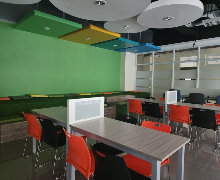 Holy Name University learning commons with students studying under a wood-slat ceiling