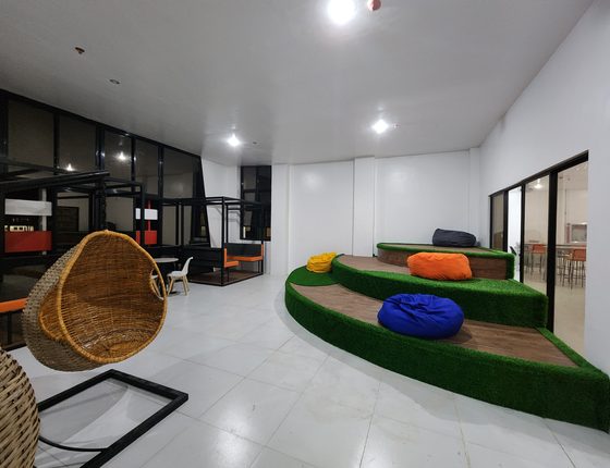 Collaborative lounge with hanging chair and green mound seating