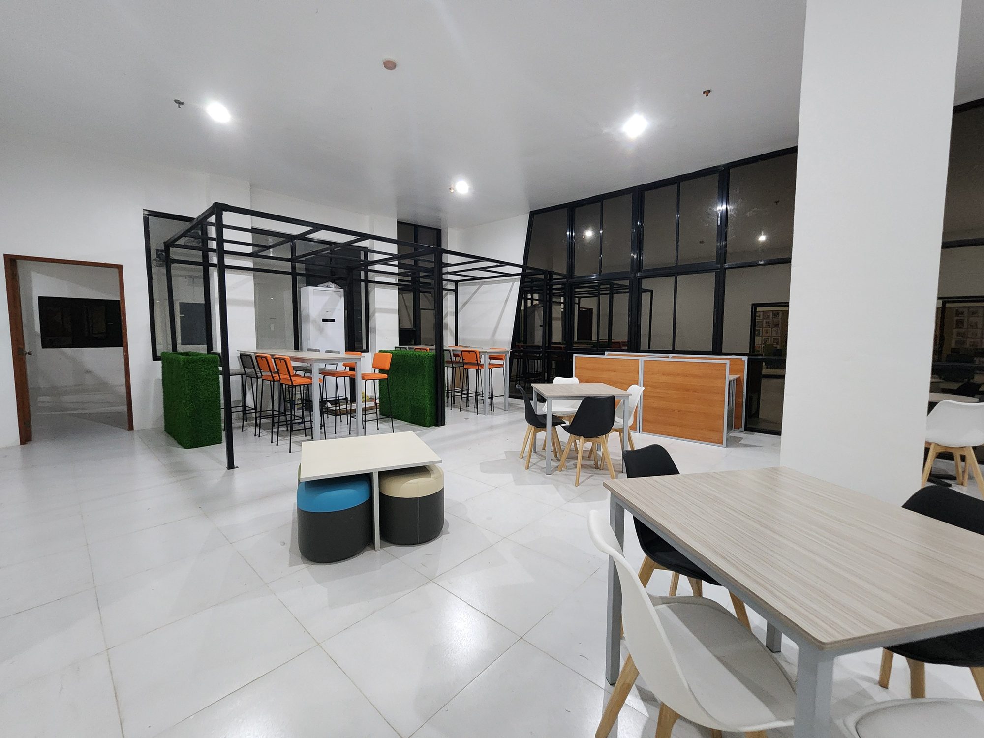 Black-framed glass study pods on an open floor