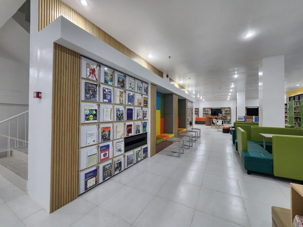 Long colorful display wall of current titles beside lounge seating