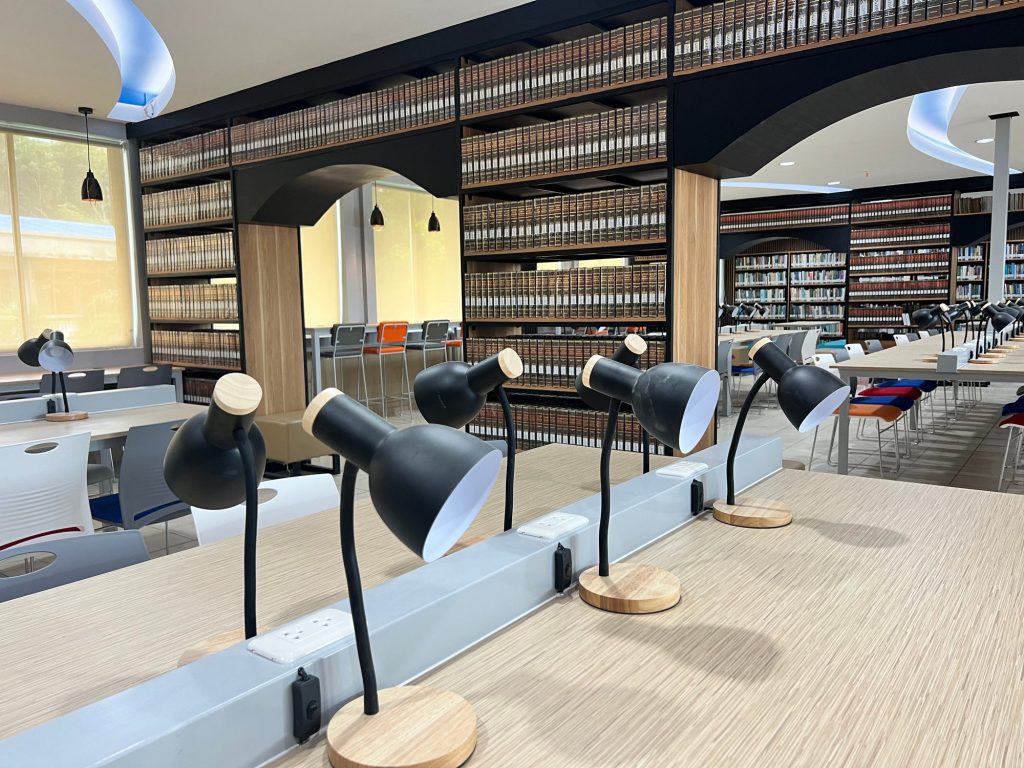 Rows of individual reading lamps along shared study tables