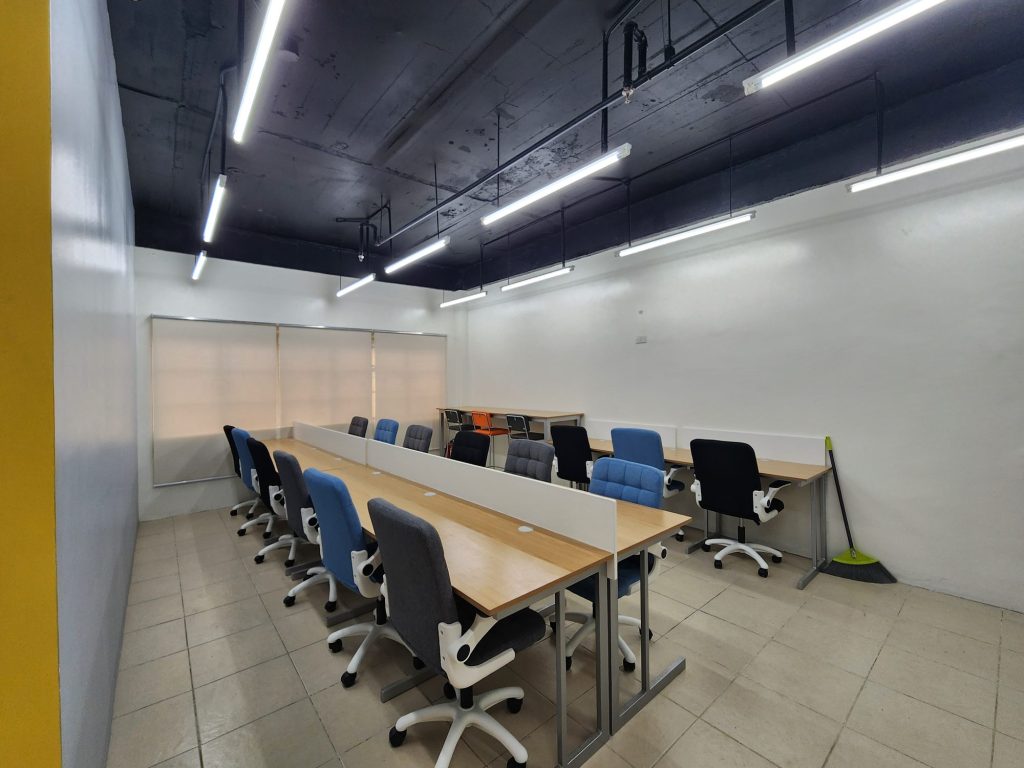 Long open study tables with blue accent chairs in a bright reading room