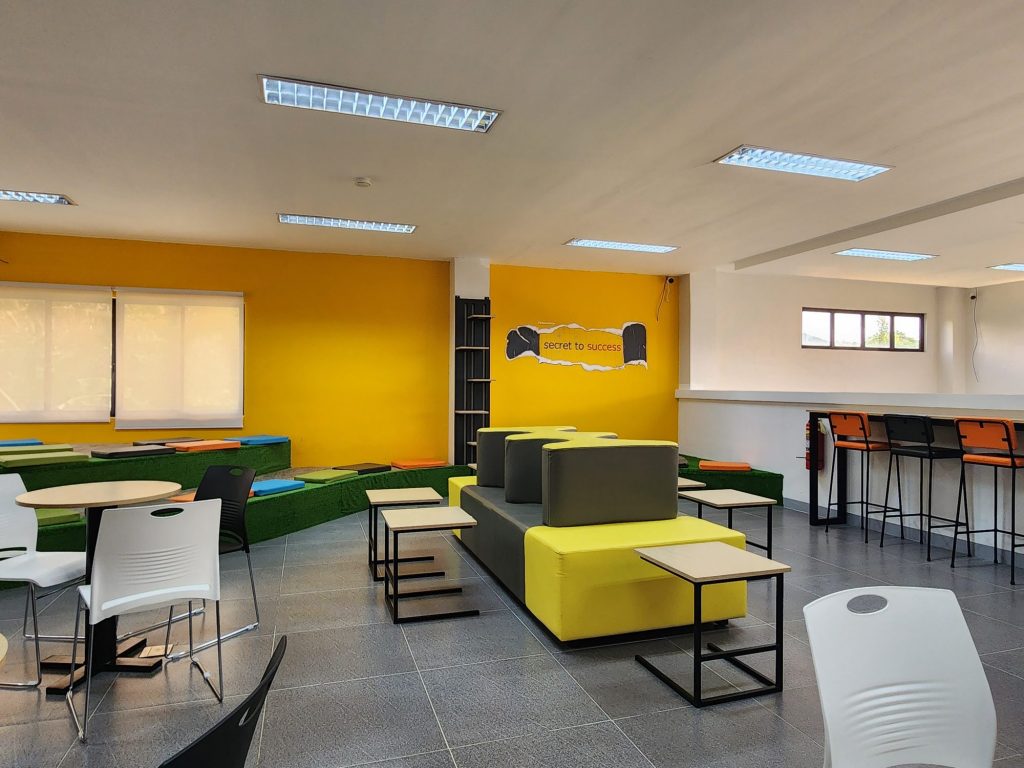 Yellow-walled study area with green booths and bar seating