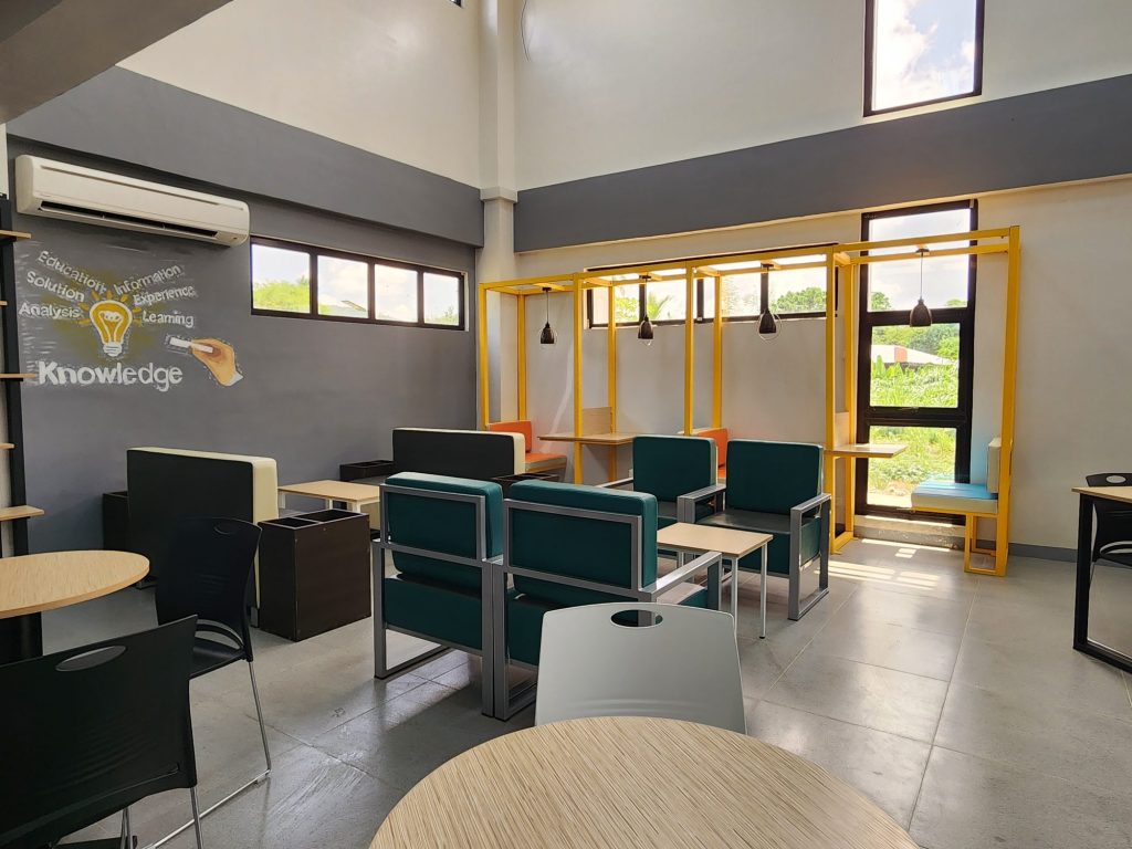 Bright study zone with colorful booths opening to greenery outside