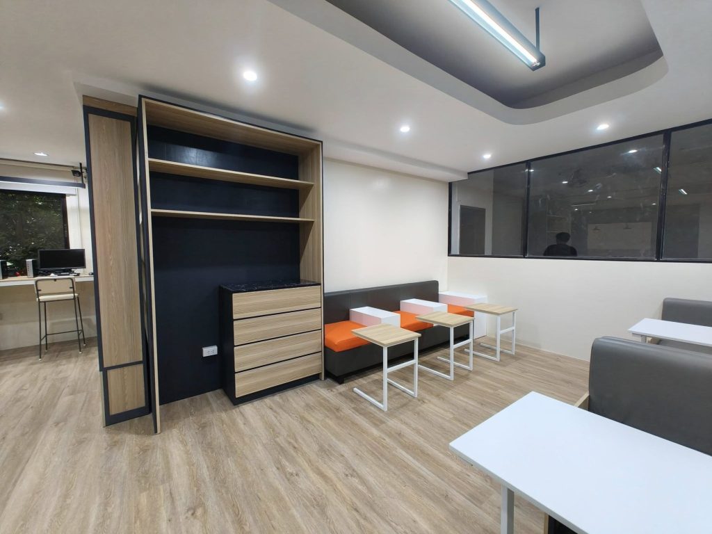 Booth seating with orange chairs beside shelving