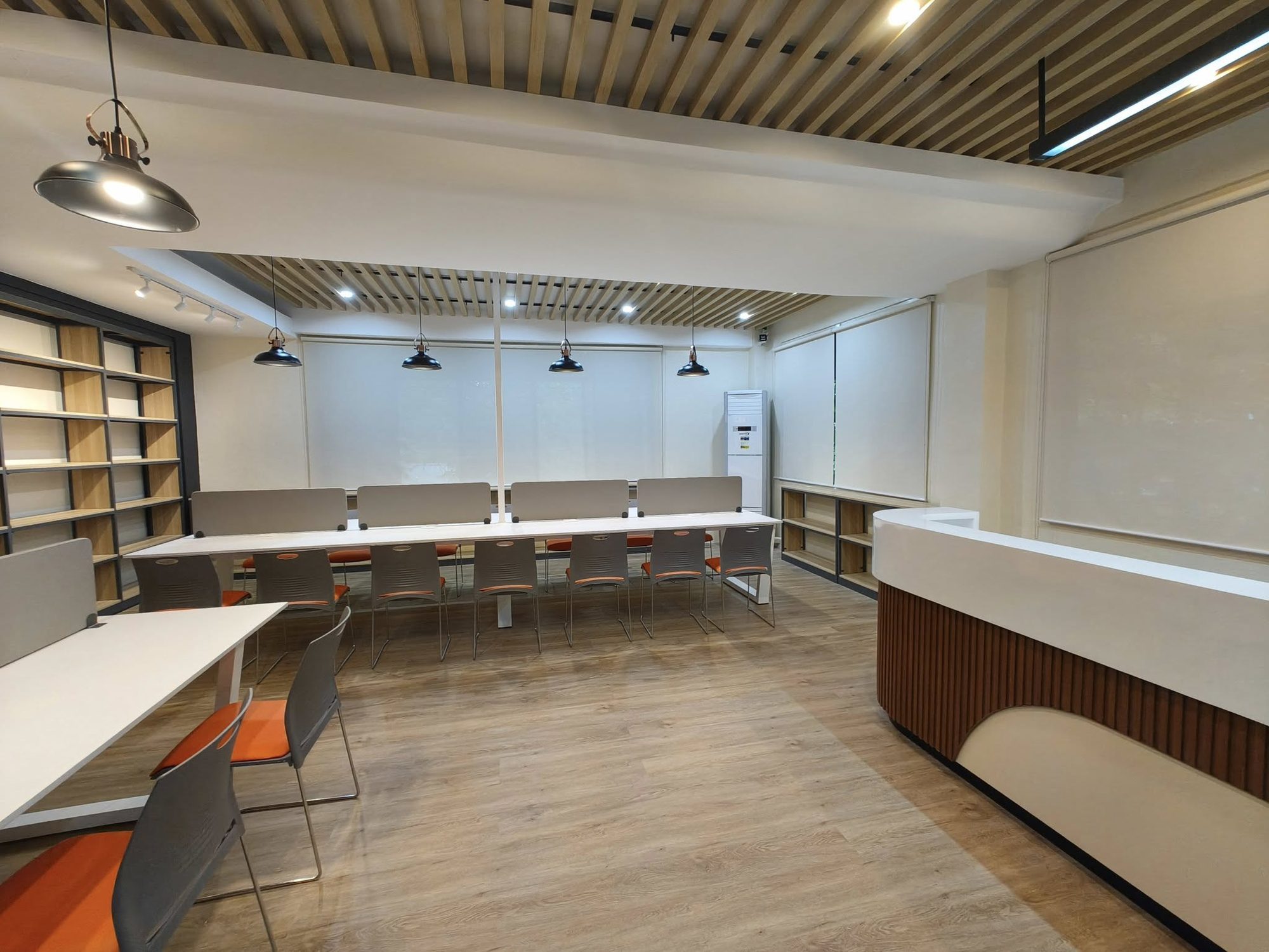 Warm wood-slat ceiling with pendant lighting over a study desk