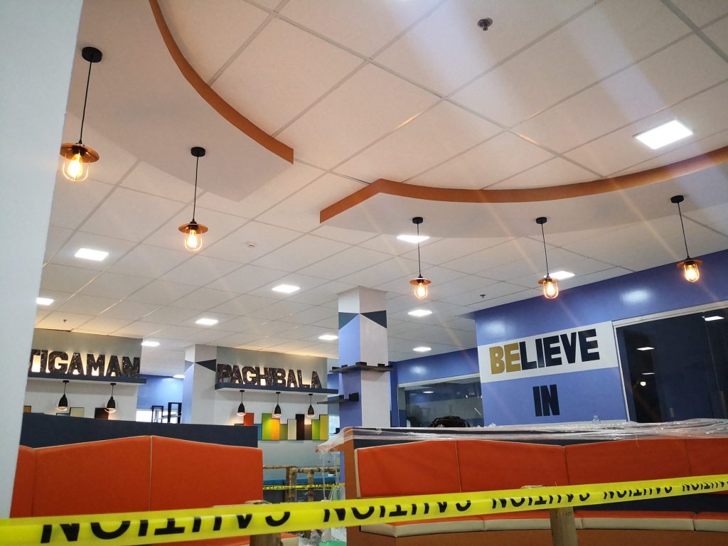 Bright blue feature wall reading Believe In above colorful lounge seating